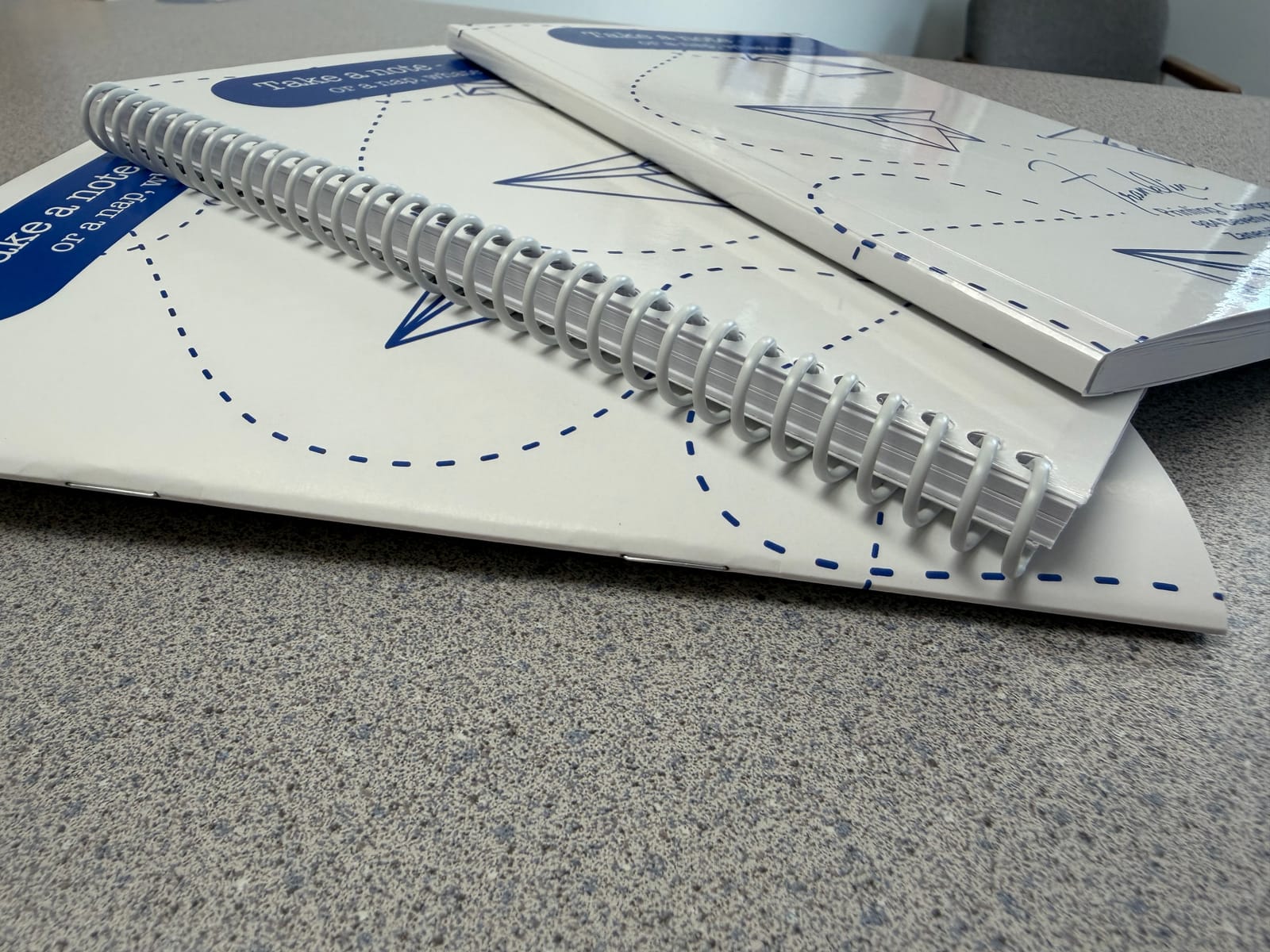 Close-up of book spines showing coil, saddle-stitch, and perfect binding options